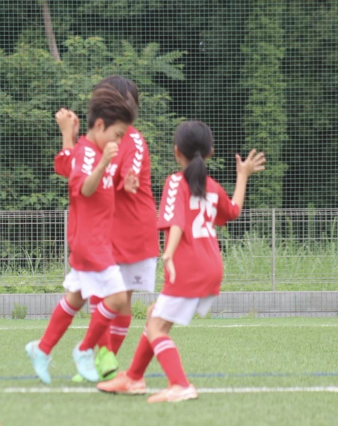 試合中にハイタッチを求めて手を上げる谷田部FCの子どもたち