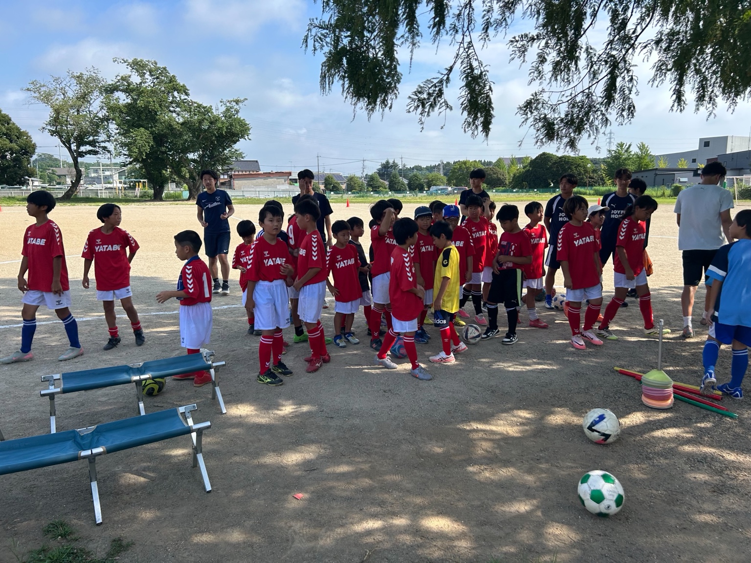 谷田部FCの子どもたちとコーチがグラウンドに集まる様子